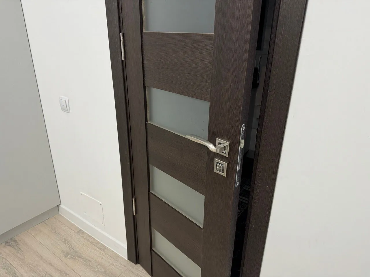 Picture of the bathroom door where the light switch is in the weirdest place